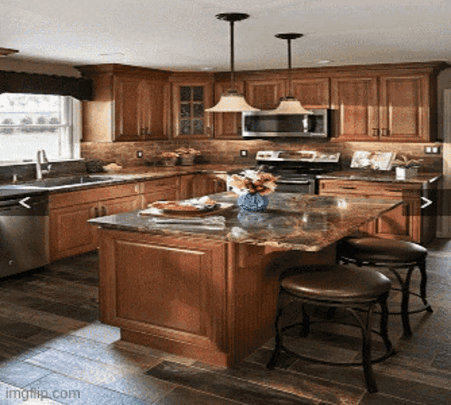 a kitchen with wooden cabinets and stainless steel appliances has a large island in the middle