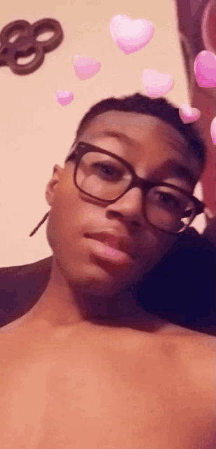 a young man wearing glasses is taking a selfie