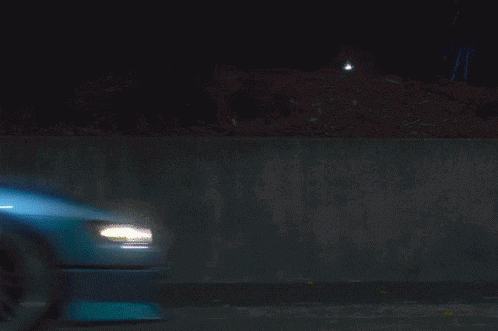 a blue car is parked next to an orange car with a sign that says tickets in the background
