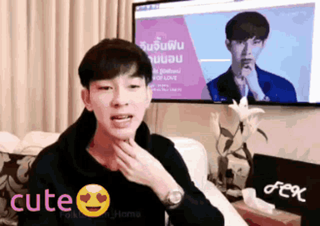 a man is sitting in front of a tv with the word cute on the bottom right