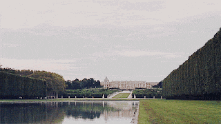 a large building is reflected in a lake surrounded by trees