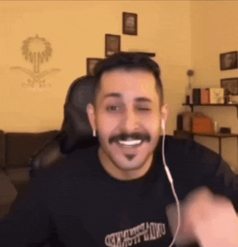 a man with a mustache is wearing headphones and a black shirt with the word naked on the front .