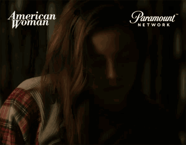 a woman with her eyes closed in front of a paramount network sign