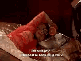 a woman in a bloody dress is laying on a bed with a tray of food and a cup of tea ..