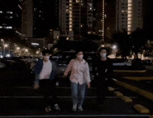 a woman wearing a mask is dancing in a parking lot .