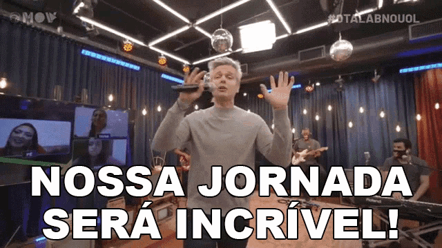 a man singing into a microphone with the words nossa jornada sera incrivel below him