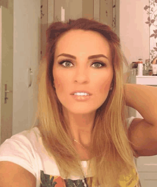 a woman is taking a selfie in front of a mirror with her hand behind her head