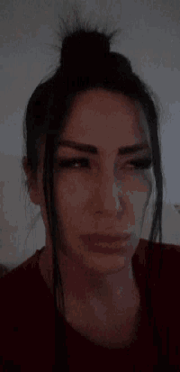 a woman with her hair in a bun is looking at the camera