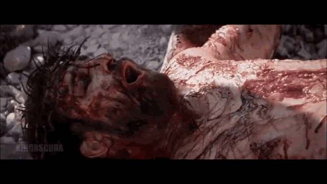 jesus is laying on the ground with blood coming out of his mouth
