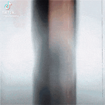 a blurry picture of a person standing in front of a glass door .