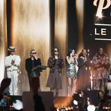 a group of people standing in front of a sign that says p le