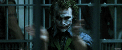 the joker is pointing his finger at the camera in a prison cell