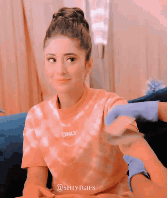 a woman wearing a tie dye shirt that says only on it