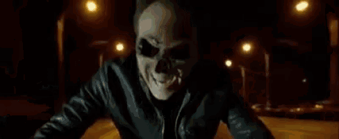 a person is riding a motorcycle down a street at night with a light behind them .