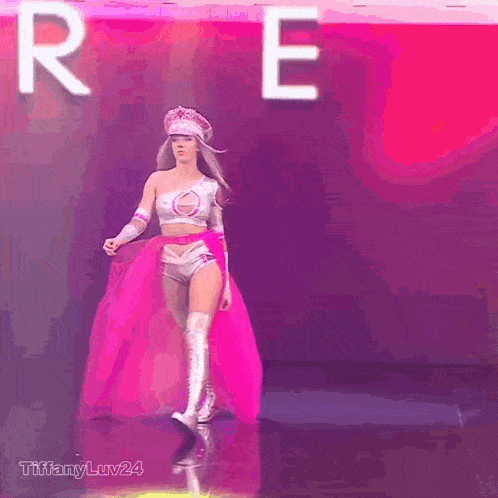 a woman in a superhero costume is walking on a stage in front of the letter r.