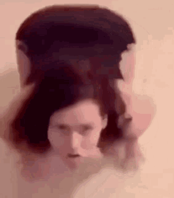 a blurry picture of a woman 's face with a man 's head behind her .