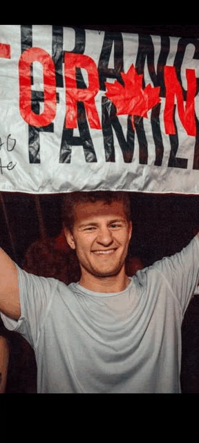a man is holding a banner that says toronto family