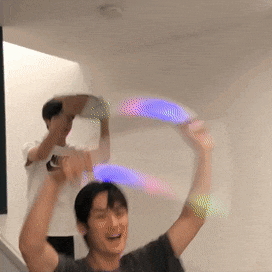 a man in a grey shirt is holding a hula hoop in his hands