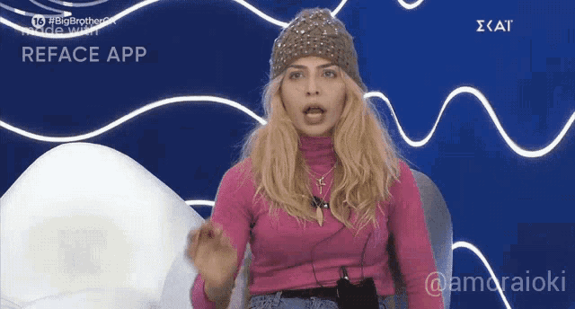 a woman wearing a pink sweater and a beanie is sitting in front of a blue background with the word reface app on it
