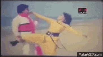 a man is kicking another man in the face in a makeagif.com video