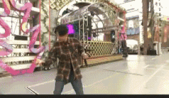 a man in a plaid shirt is dancing on a stage