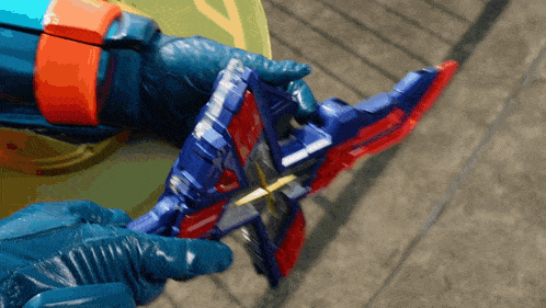 a person wearing blue gloves is holding a toy sword