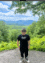 a blurry picture of a person standing on top of a hill with trees in the background .