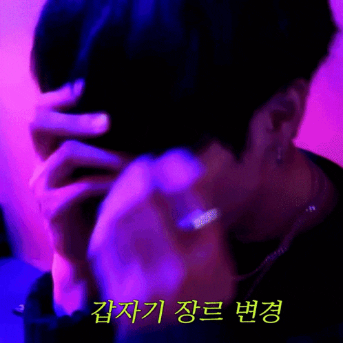 a close up of a person 's face with purple and blue lights behind them