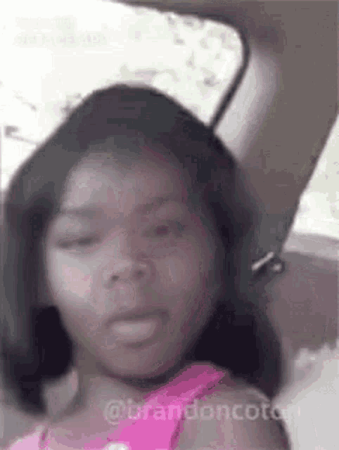 a girl is sitting in the back seat of a car with her eyes closed .