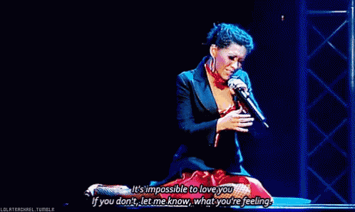 a woman singing into a microphone with the words " it 's impossible to love you if you don 't "