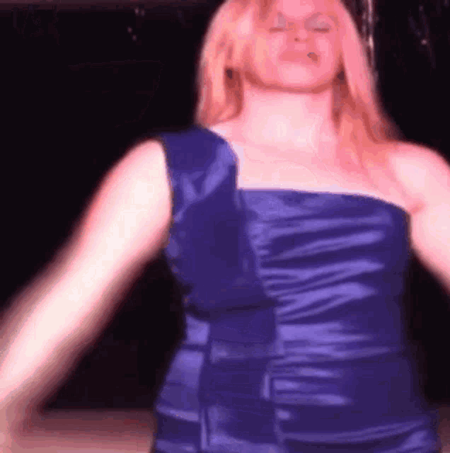 a woman in a blue dress is dancing on a stage .