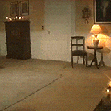 a living room with two lamps on a table and a chair