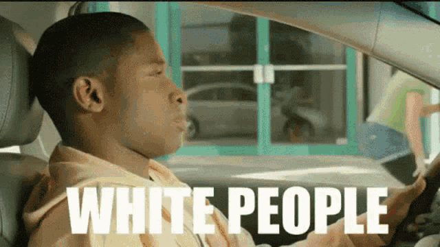 a man driving a car with the words white people written on the side