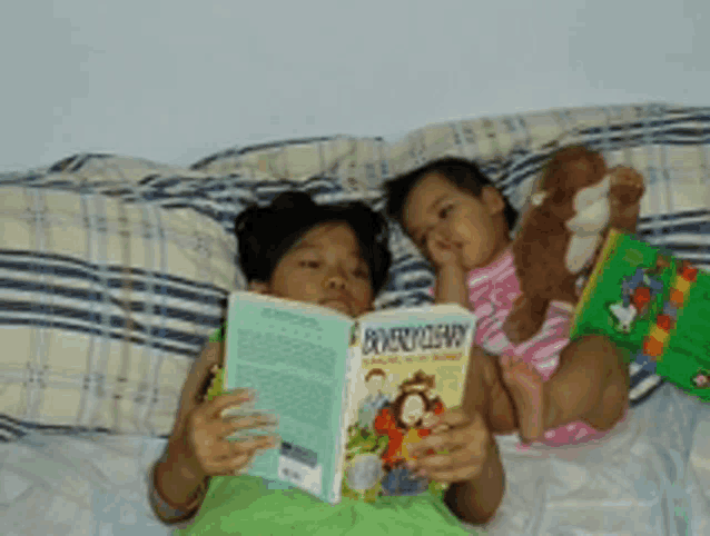 two children are laying on a bed reading a book called monkey