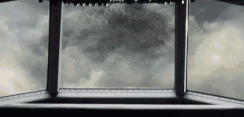 a view of a cloudy sky through a window in a building .