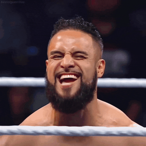 a man with a beard is laughing in a ring