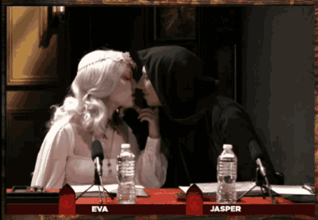 eva and jasper are sitting at a table with bottles of water
