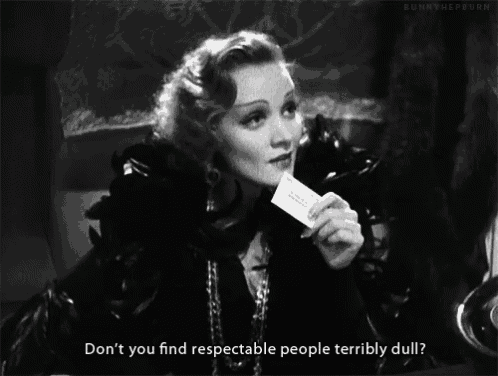 a black and white photo of a woman holding a piece of paper with the words " don t you find respectable people terribly dull "