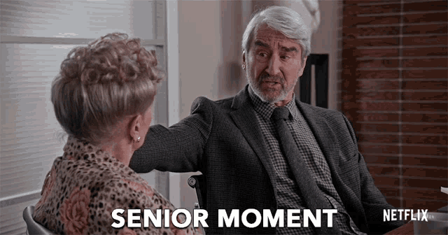 a man in a suit and tie is talking to a woman in a wheelchair and the caption says senior moment