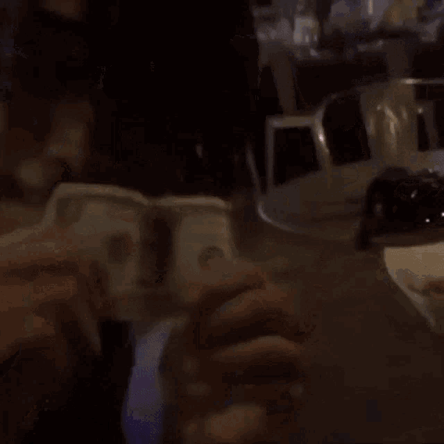 a person is holding a dollar bill in front of their face .