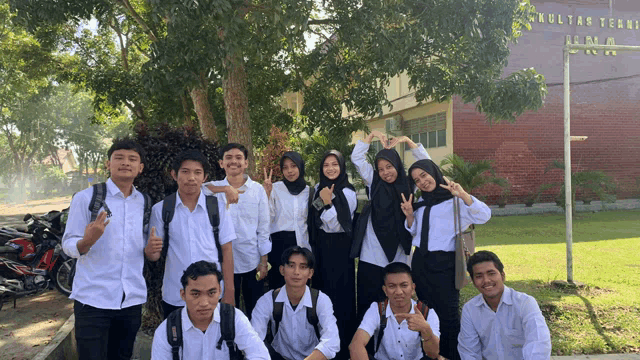 a group of students posing for a picture in front of a building that says fakultas teknik