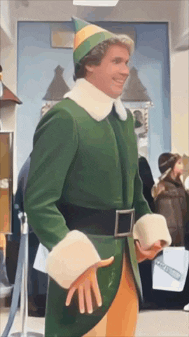 a man in a green elf costume is standing in front of a building