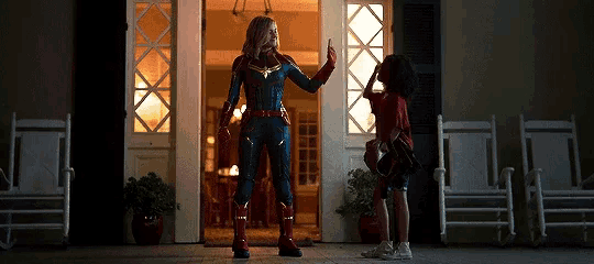 a woman in a superhero costume giving a high five to a child