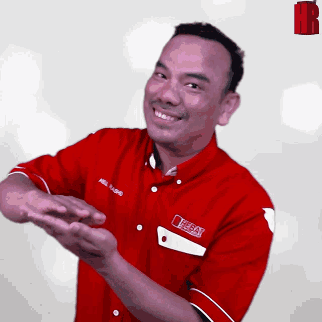 a man wearing a red shirt that says ' eeeay ' on it