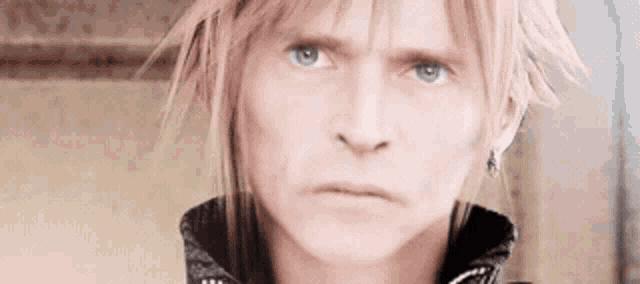 a close up of a person 's face with a serious look on his face .