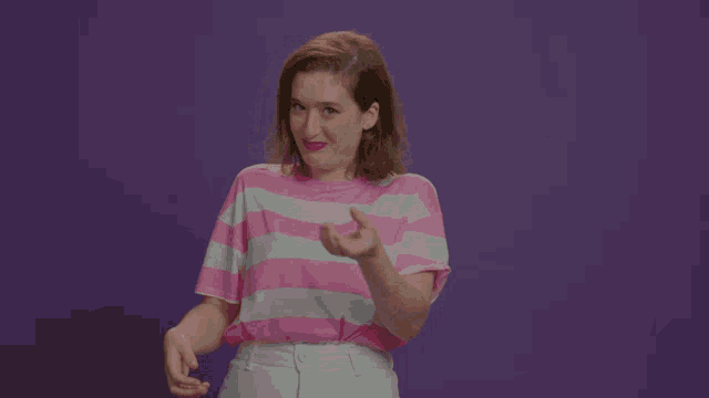 a woman is wearing a pink and white striped shirt