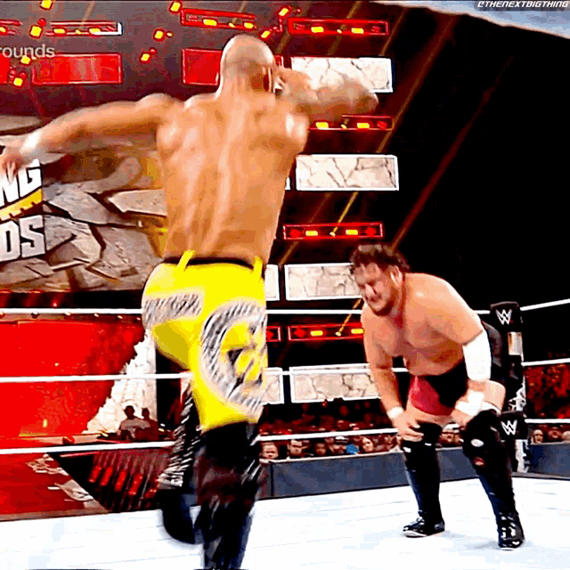 two wrestlers in a wrestling ring with a sign that says ' grounds ' in the background