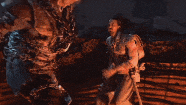 two men are fighting in a dark room with a blurred background