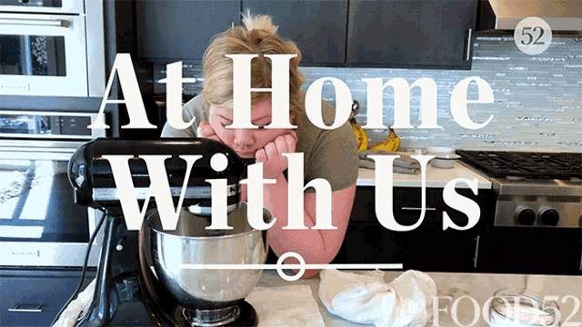 a woman sitting in front of a mixer with the words at home with us above her