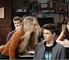 a group of people including a boy and a girl are sitting in a room with pictures on the walls